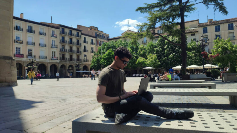 Entrepreneur working on a laptop in Spain while managing a business remotely