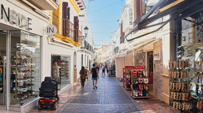 Lively shopping street with shops and pedestrians on the Costa del Sol, Spain